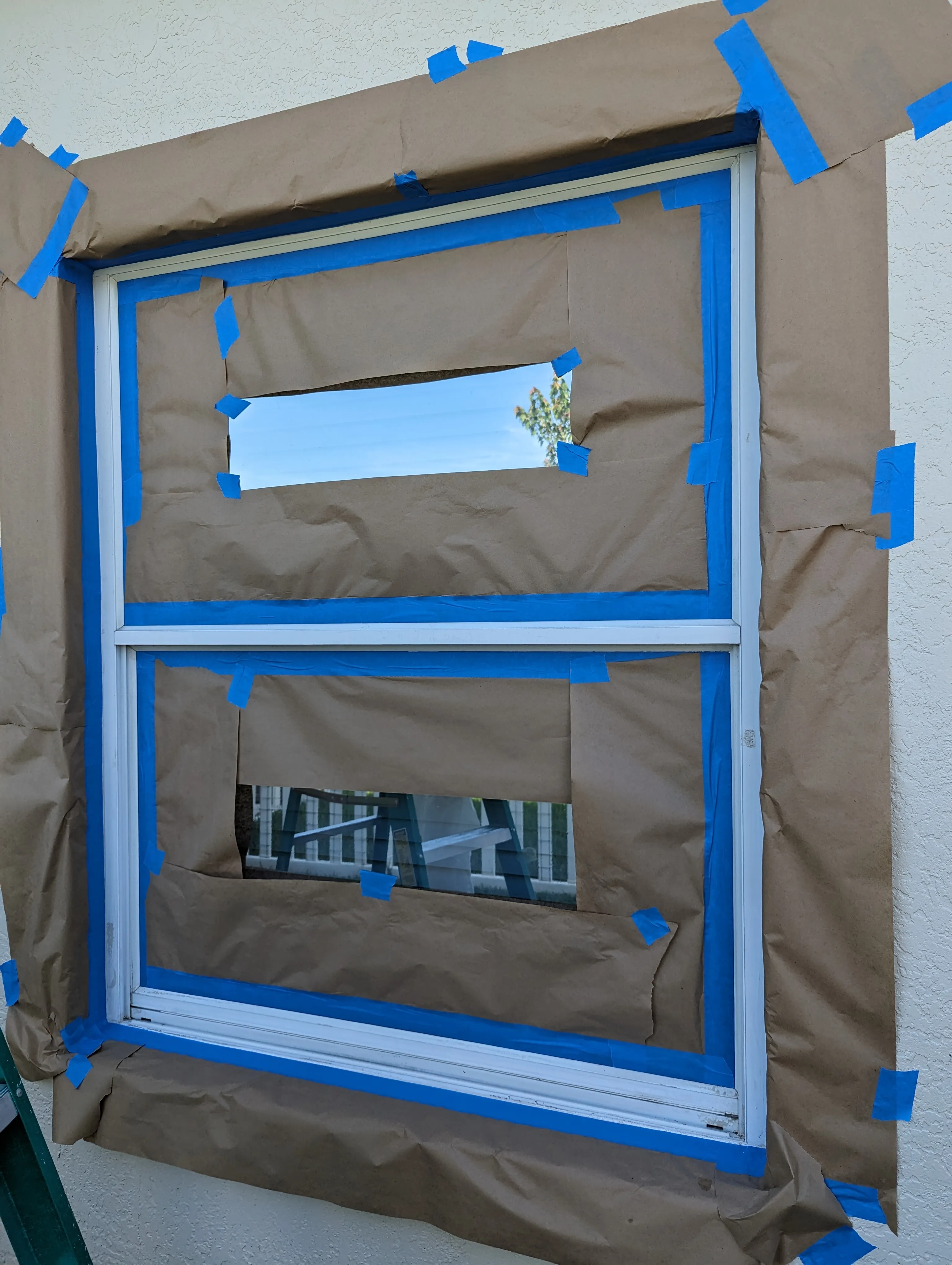 Before: Exterior aluminum window frame masked and prepped, then repainted crisp white against a fresh stucco wall